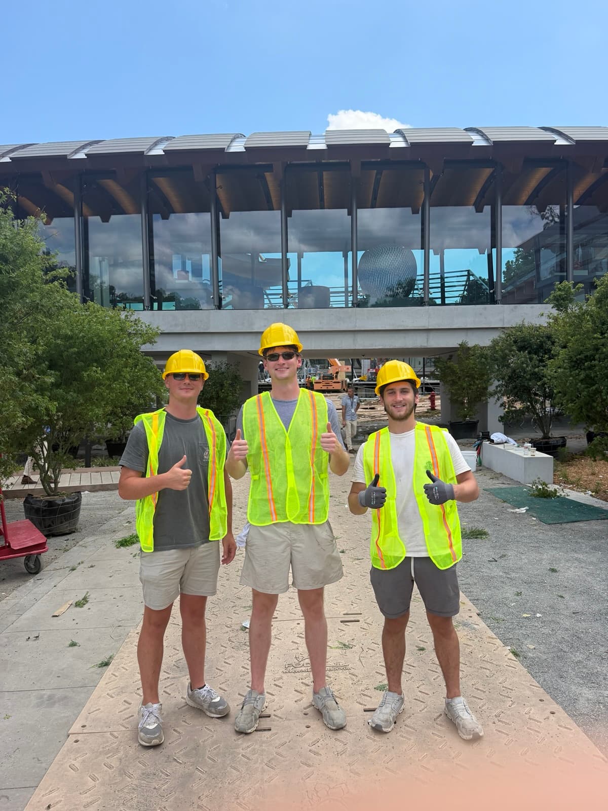 Three Boss Hog crew members wearing hard hats and safety vests at an outdoor worksite