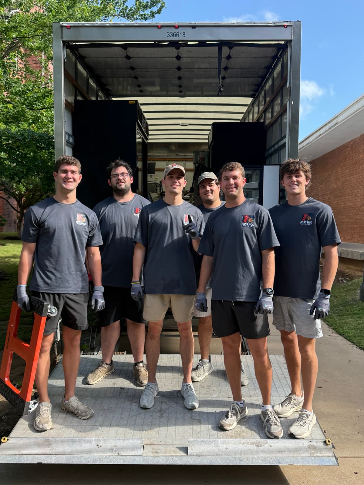 Boss Hog Moving crew in company shirts standing together on a truck ramp