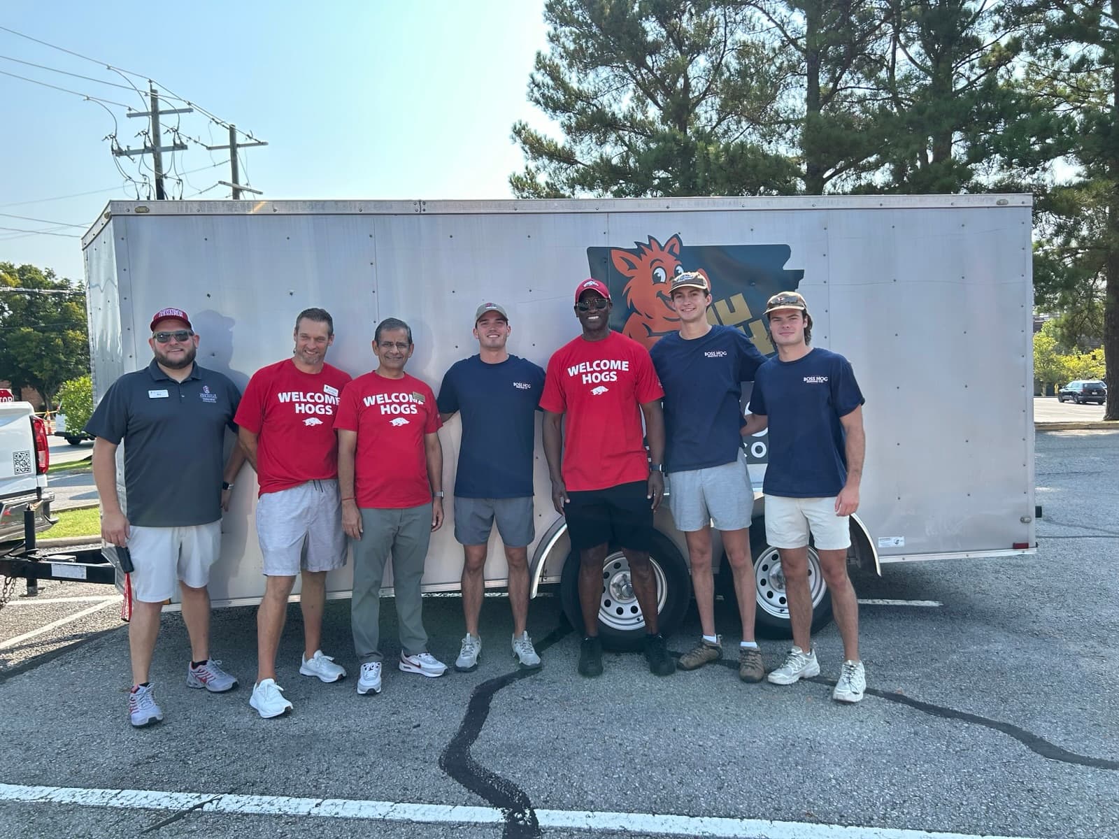 Boss Hog crew and people in Welcome Hogs shirts gathered beside the company trailer