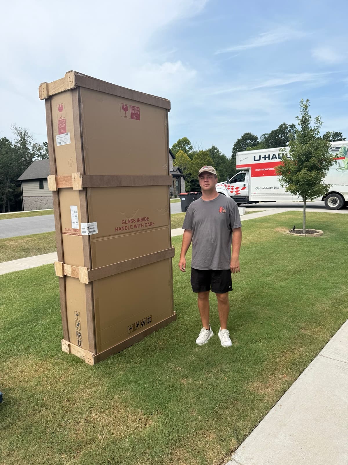 Boss Hog mover standing beside a large protective shipping crate during a delivery