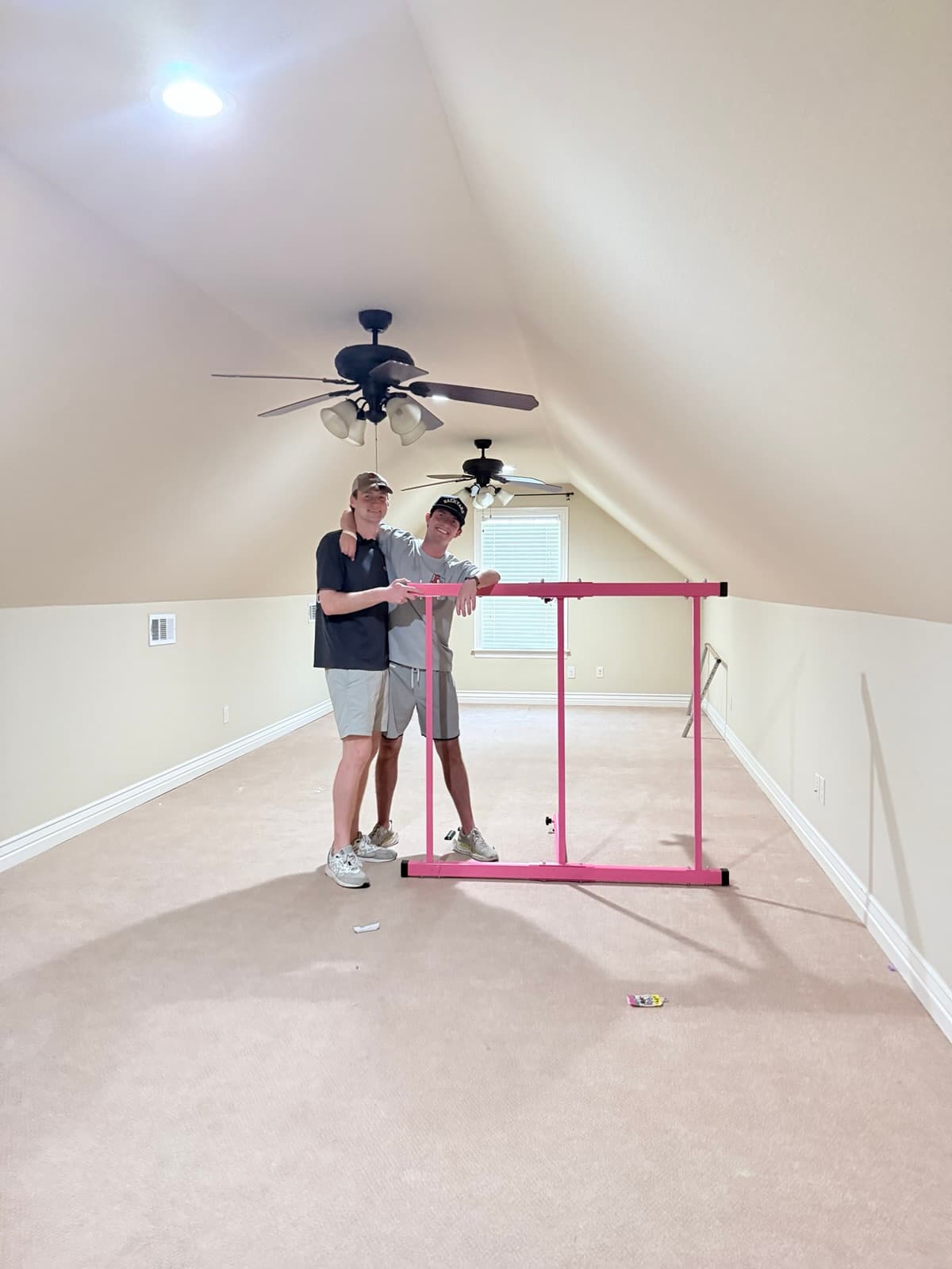 Two Boss Hog crew members with a furniture frame inside a home